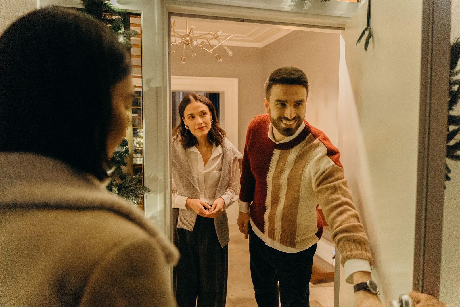 A host warmly welcoming a guest at their front door